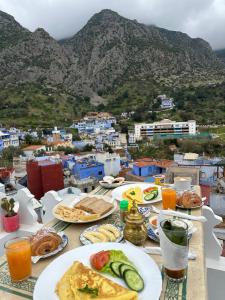 a table with plates of food on top of a city at Ahlan Riad Chefchaouen in Chefchaouen