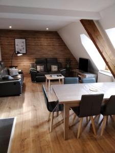 a living room with a table and chairs at Les Toits d'Hélène in Ammerschwihr