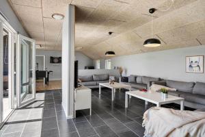 a living room with a couch and tables and a piano at JB500-Brovst-Kronvildtvej-31 in Tranum Strand