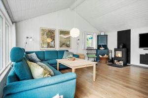 a living room with a blue couch and a table at 30717-Odder-Alrovej-153 in Amstrup