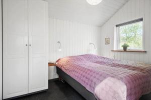 a bedroom with a pink bed and a window at 30717-Odder-Alrovej-153 in Amstrup