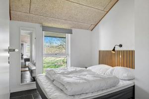 a bedroom with a large bed with white sheets at JB500-Brovst-Kronvildtvej-31 in Tranum Strand +40 photos