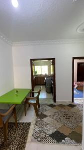 a living room with a green table and a bench at شقة مفروشة in Ajloun