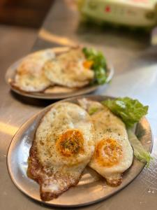 two plates of food with eggs and greens on a table at Croatia Palace - Ravna Gora in Ravna Gora