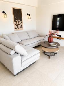 a living room with a white couch and a table at Elysian View Lefkakia in Nafplio