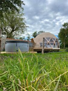 a dome tent sitting on top of a grass field at Dôme géodésique - Baie de Somme in Favières +10 photos