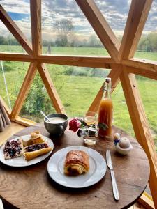 a table with two plates of food and a window at Dôme géodésique - Baie de Somme in Favières