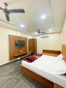 a bedroom with a bed and a flat screen tv at Hotel Nakshatra in Guna