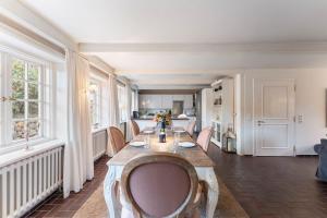 a dining room with a long table and chairs at Friesenhaus Hideaway Hüs in Morsum
