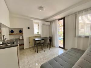a kitchen and living room with a table and a couch at Tao House in Taormina