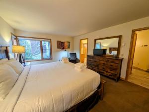 a bedroom with a large white bed and a mirror at Ski Run 201 by SummitCove Lodging in Colorado in Keystone
