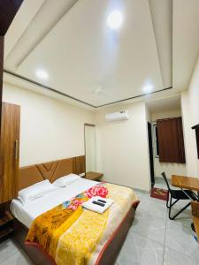 a bedroom with a bed with a phone on it at Hotel Nakshatra in Guna