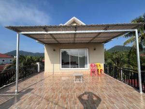 a pergola with two chairs and a table on a deck at El Ling guesthouse in Kep