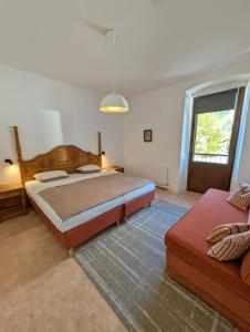 a bedroom with a large bed and a couch at City Center Rooms in Mayrhofen