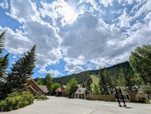 a street in a town with trees and a cloudy sky at Ski Run 302 by SummitCove Lodging in Colorado in Keystone