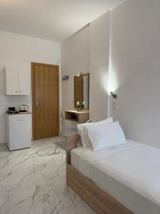 a white bedroom with a bed and a kitchen at Florida Hotel & Apartments - Adults Only in Rhodes Town