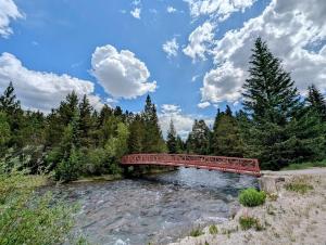 a red bridge over a river in a forest at Ski Run 302 by SummitCove Lodging in Colorado in Keystone
