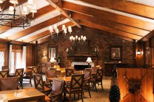 a large room with tables and chairs and a fireplace at Pine Needles Lodge in Southern Pines