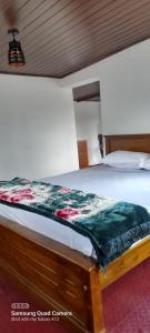 a bed with a quilt on it in a room at Himidiri Villa in Nuwara Eliya