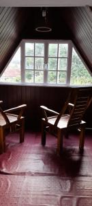two benches in a room with a large window at Himidiri Villa in Nuwara Eliya +1 photo