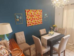 a dining room with a table and chairs and a blue wall at 'Belkaz in Port-Gentil