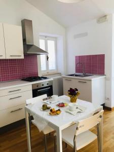 a kitchen with a white table and chairs with food on it at B&B Porta Girone in Civitanova Alta