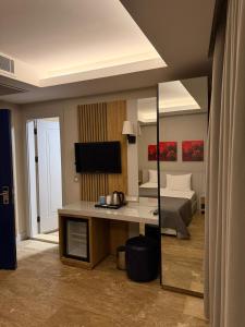 a bedroom with a bed and a desk with a mirror at The Alaçatı Ariel Hotel in Çeşme