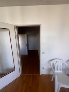 an empty room with a chair and a hallway at Freilassing Unterkünfte in Freilassing
