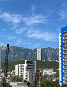 a city with buildings and mountains in the background at Cerca de todo en San Jerónimo in Monterrey