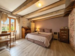 a bedroom with a bed and a desk and a piano at Le Doux Nid in Chanaz
