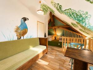 a living room with a large peacock mural on the wall at Le Doux Nid in Chanaz