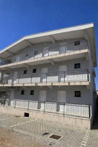 a white building with balconies on the side of it at MAAR Kovačić Apartmani in Zaton