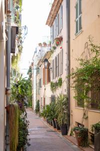 an alley with plants and buildings on a street at Les Petits Volets 2 à 100m de la mer in Antibes