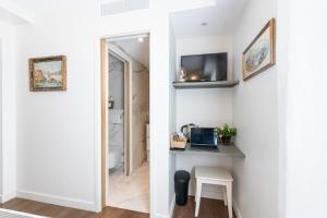a room with a hallway with a table and a laptop on a counter at Les Petits Volets 2 à 100m de la mer in Antibes +21 photos