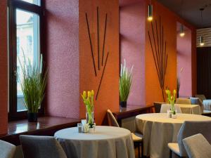 a dining room with two tables and chairs and flowers at GRAND Restaurant&Hotel in Daugavpils