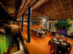 a restaurant with tables and chairs in a room at Galpothuyaya Eco Lodge Kandalama in Dambulla