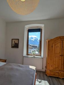 a bedroom with a bed and a window with a mountain at City Center Rooms in Mayrhofen +18 photos