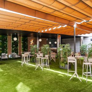 a patio with tables and chairs on the grass at Hotel Princesa De Eboli in Pinto