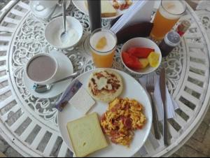 a table with a plate of breakfast food and drinks at Hotel River City in Montería
