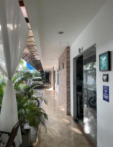 a hallway of a building with plants in it at Hotel River City in Montería