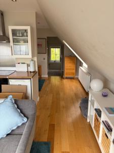 a living room with a couch and a kitchen at Rockpool Apartment in Acharacle