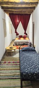 a bedroom with a bed and a table in a room at Kasbah d'hotes ayad in Moulay Brahim