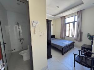 a bedroom with a bed and a shower and a toilet at Phương Nhi Motel in Danang +1 photo