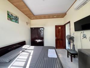 a bedroom with a bed and a flat screen tv at Phương Nhi Motel in Danang