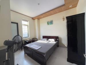 a small bedroom with a bed and a fan at Phương Nhi Motel in Danang