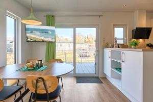 a kitchen and dining room with a table and chairs at Ostseecamp Haus Im Eck 142 mit kostenfreier Saunanutzung in Scharbeutz