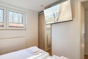 a bedroom with a bed and a tv on the wall at Ostseecamp Haus Im Eck 142 mit kostenfreier Saunanutzung in Scharbeutz