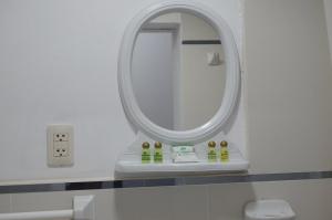 a bathroom with a round mirror and a sink at Hotel Acropolis Callao in Lima