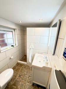 a white bathroom with a sink and a toilet at Fischerhus in Fehmarn +22 photos