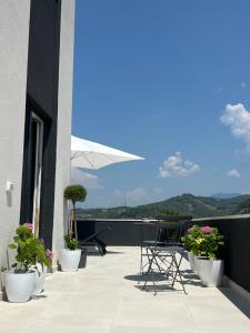 a patio with chairs and potted plants on a building at Home DeLuis in Gramsh